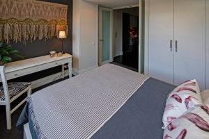 Wall hanging, sliver accessories, pink and white cushions, distressed desk and chair This is an example of an eclectic master bedroom in Sydney.