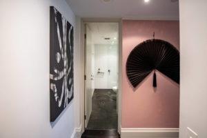 Accent pink wall Design ideas for an eclectic hallway in Sydney with pink walls, dark hardwood floors and black floor.