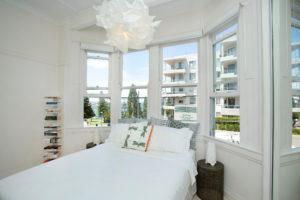 This is an example of a contemporary bedroom in Sydney with white walls, light hardwood floors and no fireplace.