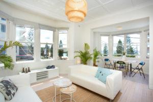 This is an example of a mid-sized contemporary open concept living room in Sydney with white walls, light hardwood floors, no fireplace and no tv.