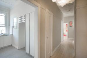 Design ideas for a small contemporary hallway in Sydney with white walls and light hardwood floors.