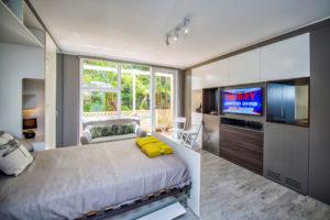 Inspiration for a small contemporary bedroom in Sydney with grey walls, light hardwood floors and no fireplace.