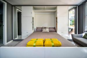 Small contemporary bedroom in Sydney with grey walls, light hardwood floors and no fireplace.