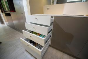 Small contemporary galley separate kitchen in Sydney with a single-bowl sink, flat-panel cabinets, solid surface benchtops, mirror splashback, light hardwood floors and no island.