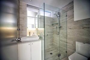 Photo of a small contemporary bathroom in Sydney with flat-panel cabinets, white cabinets, a corner shower, a two-piece toilet, ceramic tile, ceramic floors, a vessel sink, solid surface benchtops and a hinged shower door.