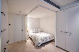 Design ideas for a small contemporary loft-style bedroom in Sydney with light hardwood floors and no fireplace.
